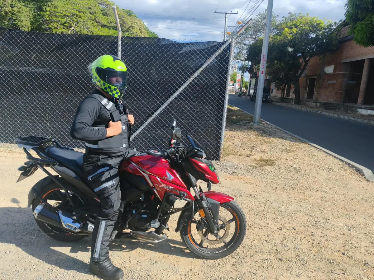 Mensajero de GRM junto a su moto en Girardot